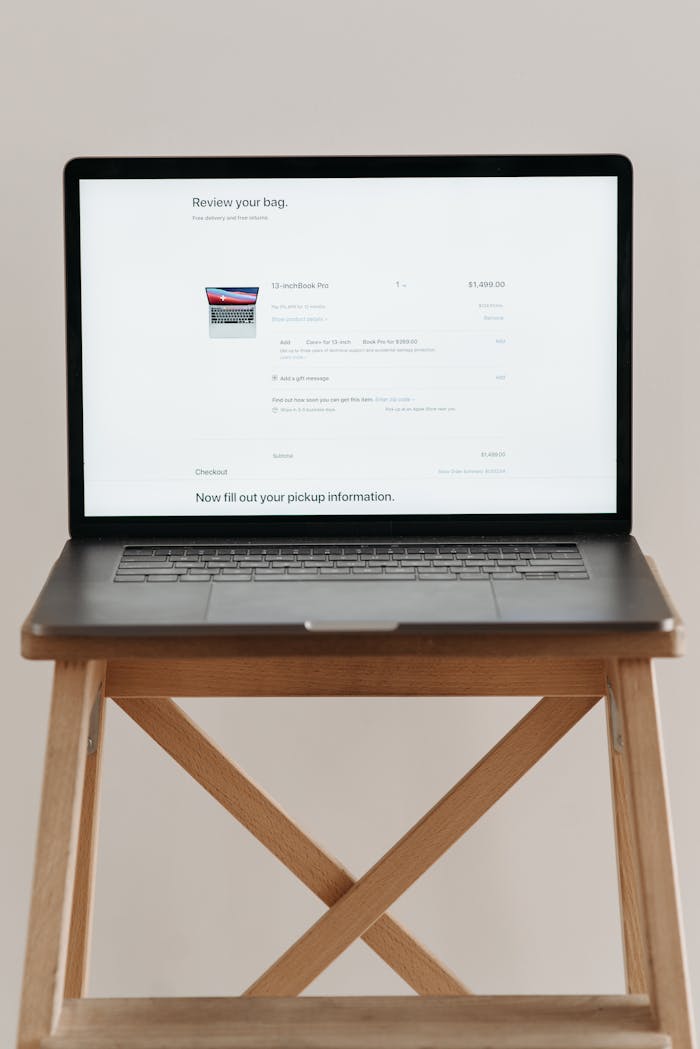 get-in-touch Open laptop displaying checkout screen on a wooden stand, ideal for e-commerce themes.